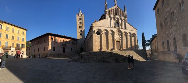 People in historic building against sky in city