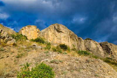 Low angle view of rocks on mountain against sky