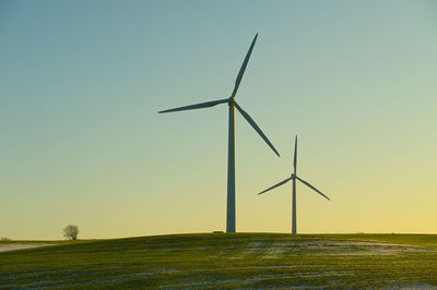 Windmill on field against clear sky