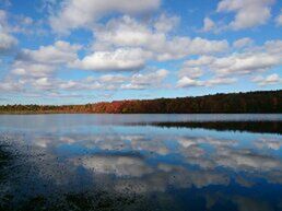 Scenic view of lake against cloudy sky