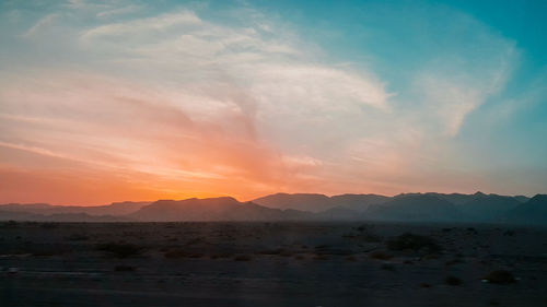 Scenic view of silhouette mountains against sky during sunset