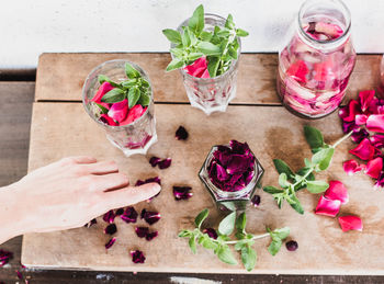 Cropped hand of woman holding christmas decorations on table
