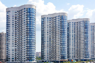 The elegant blue and white facades of new multi-storey buildings against the blue sky.