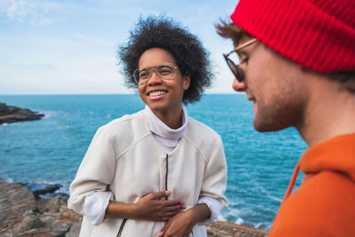 Portrait of smiling young man by sea against sky