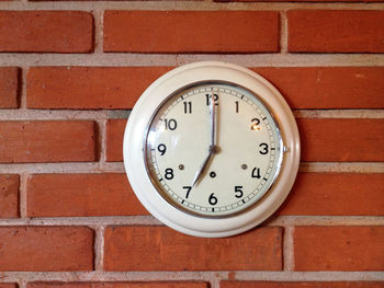 Close-up of clock mounted on brick wall