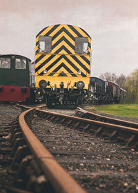 Train by railroad tracks against sky