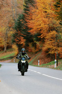 Rear view of man riding motorcycle on road