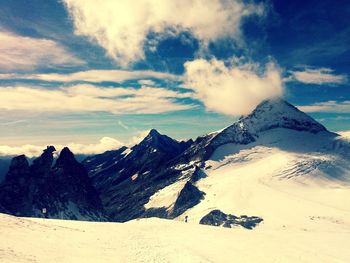 Scenic view of mountain range against cloudy sky