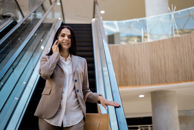 Portrait of young woman standing in city