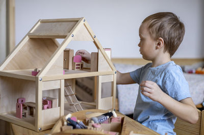 Boy playing with wooden toy at home