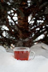 Close-up of coffee cup on glass during winter