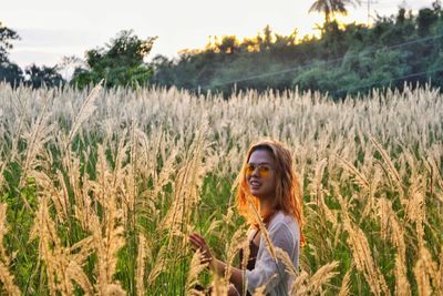 Portrait of young woman standing in field