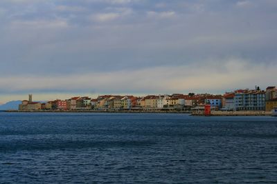 View of townscape by sea against sky