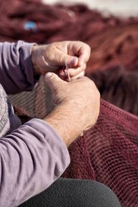 Midsection of man holding fishing net