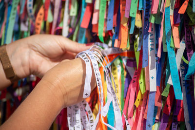 Tourist hands tying souvenir ribbons on the railing of the senhor do bonfim church