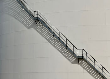 Low angle view of industrial staircase against gas silo 