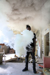 Portrait of man standing with smoke in abandoned home