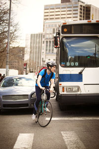 Man riding bicycle on road in city