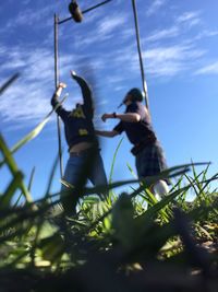 Low angle view of boy on swing against sky