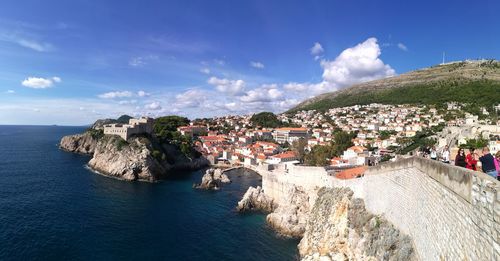 Panoramic view of townscape in front of sea against sky