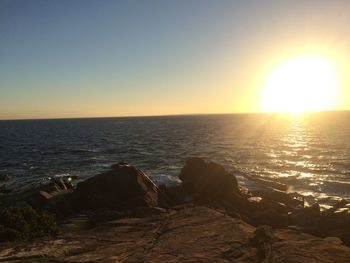 Scenic view of sea against clear sky during sunset