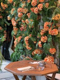Fresh flowers in vase on table against plants