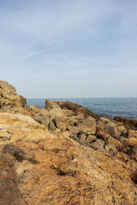 Rock formations on beach against sky