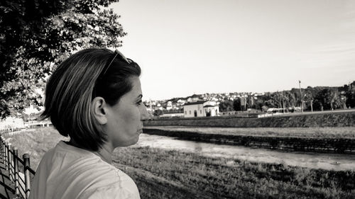 Portrait of woman looking away against sky