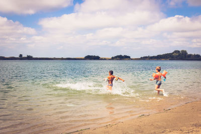 People enjoying on beach against sky