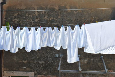 Low angle view of clothes drying against the wall. white laundry