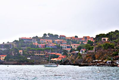 Town by river against clear sky