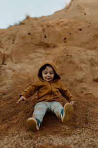 Low angle view of boy playing on dirt