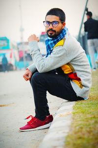 Young man wearing sunglasses sitting outdoors