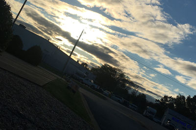 View of city street against sky at sunset