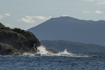 Scenic view of sea and mountains against sky