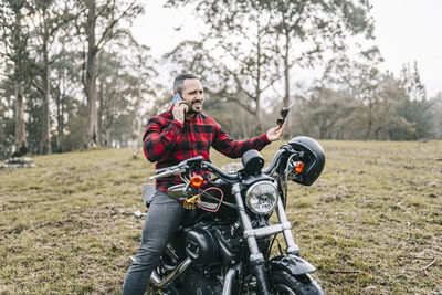 Full length of man riding motorcycle on field