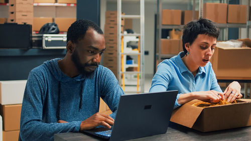 Side view of man using laptop at table