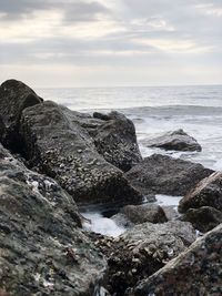 Rocks on beach against sky