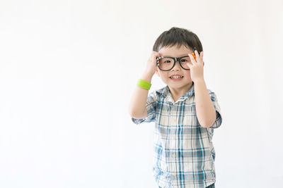 Portrait of boy standing against white background