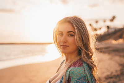 Portrait of young woman standing at beach