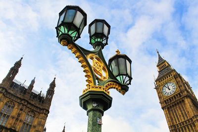 Low angle view of clock tower against cloudy sky