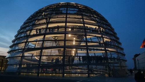 Low angle view of illuminated reichstag building against sky at dusk