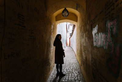 Woman exploring a narrow street in brasov city, romania.