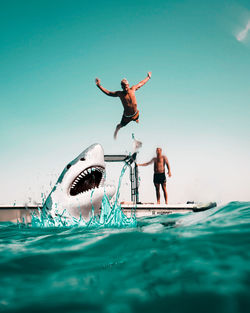 People enjoying in swimming pool against sea