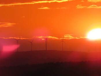 Scenic view of silhouette landscape against orange sky