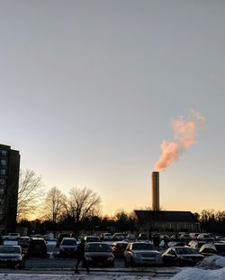 Cars on street against sky during sunset