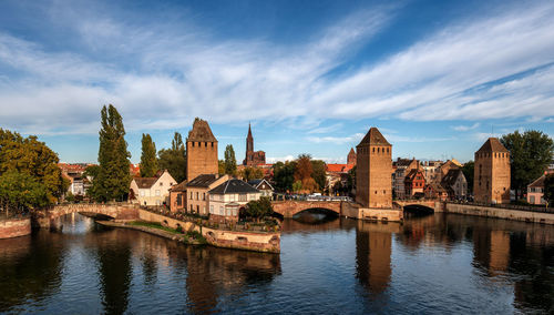 Arch bridge over river against buildings in city