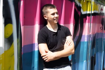 Young man standing against metal