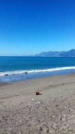 Scenic view of beach against clear blue sky