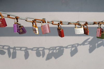 Close-up of multi colored padlocks hanging against wall